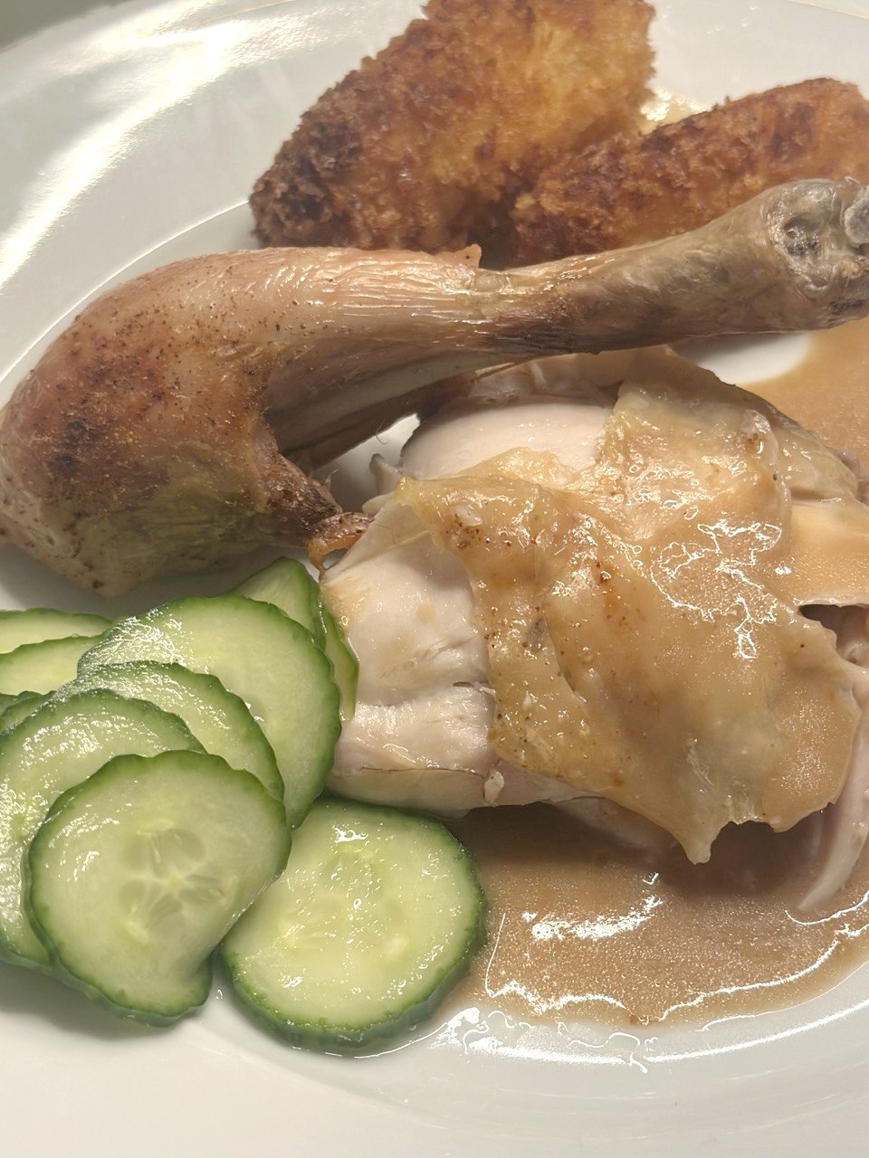 Agurkesalat serveret ved siden af helstegt kylling med sovs